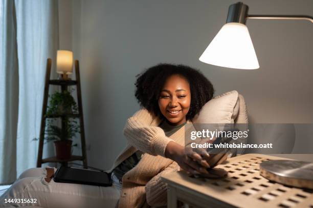 woman putting her smartphone on wireless charger - telephone switch stockfoto's en -beelden