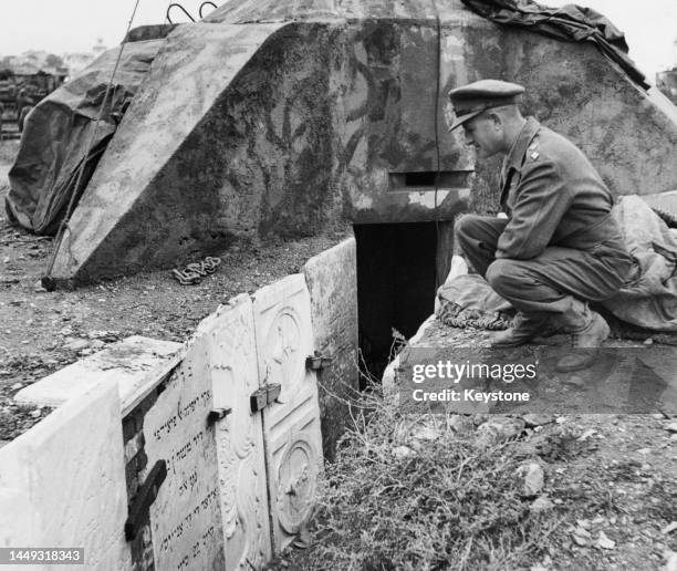 British Army officer inspects the Jewish gravestone markers taken from the desecrated Jewish cemetery of Salonica and used to support a trench line...