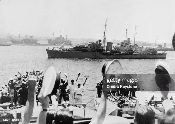 Cheered by the ship's company from HMS Kelvin, Captain Lord Louis Mountbatten waves to the crews of the remaining ships of the Royal Navy 5th...