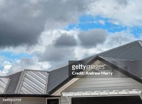 Classic house roof, corrugated metal, clouds blue sky