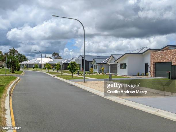 housing development new houses street clouds - classic car point of view stock-fotos und bilder