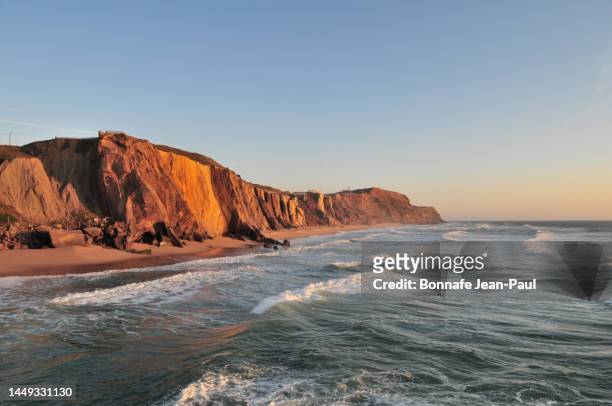 sunset on the cliffs near cascais ( portugal ) - surfers in the sea at sunset stock pictures, royalty-free photos & images