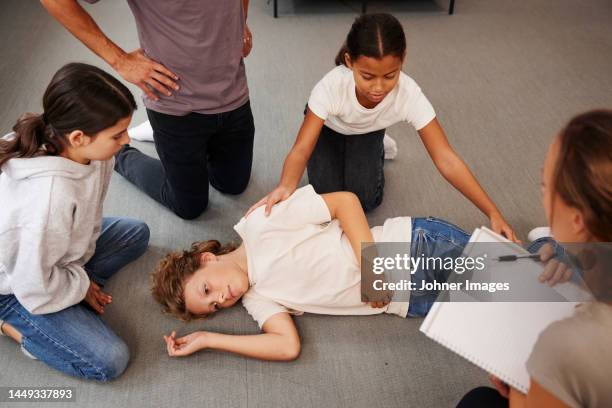 teachers giving first aid training - recovery position stock pictures, royalty-free photos & images