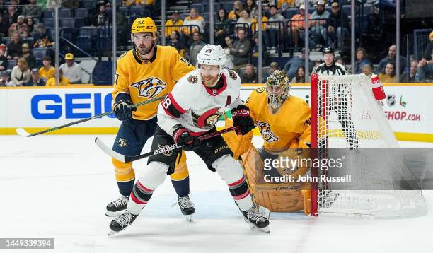 Claude Giroux of the Ottawa Senators battles in front of the net against Dante Fabbro and Juuse Saros of the Nashville Predators during an NHL game...