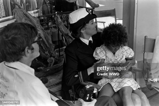 Tyne Daly cradles daughter Kathryne Dora Brown during production of the TV movie "The Entertainer" in Los Angeles on August 8, 1975.