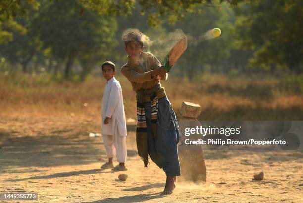 Mohammad Sarfraz, 12 years old bats on a patch of ground as boys play cricket near Jinnah International Airport on December 15, 2022 in Karachi,...