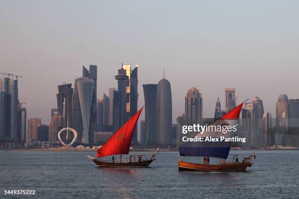 Boats with sails showing the flags of the nations Morocco and Croatia who will play in the third place play off match sail in-front of the Doha...