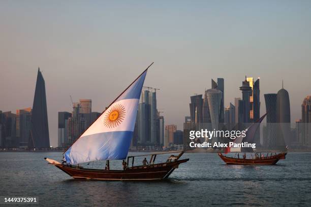 Boats with sails showing the flags of the nations Argentina and France who will play in the final match sail in-front of the Doha skyline on The...