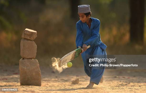 Ziauriehmen Sarfraz, 13 years old bats on a patch of ground as boys play cricket near Jinnah International Airport on December 15, 2022 in Karachi,...