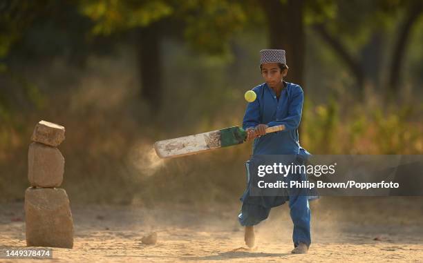 Ziauriehmen Sarfraz, 13 years old bats on a patch of ground as boys play cricket near Jinnah International Airport on December 15, 2022 in Karachi,...
