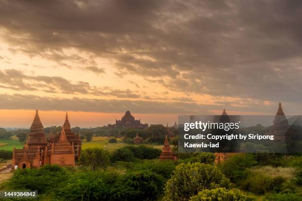 the overcast and cloudy sky over the old bagan pagodas at sunrise - theravada stock pictures, royalty-free photos & images