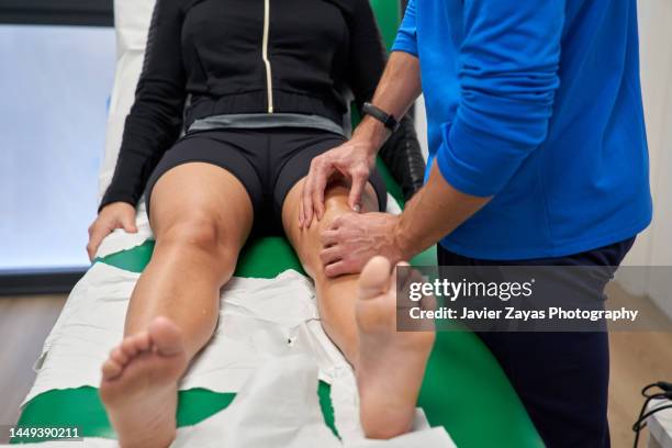 unrecognizable physiotherapist assisting in the recovery of a woman's knee after meniscus surgery - meniscus stock pictures, royalty-free photos & images