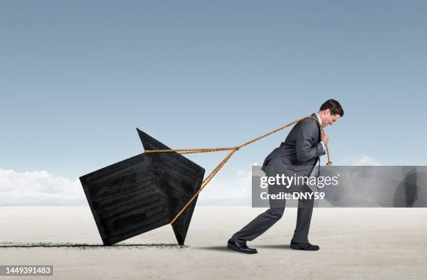 man pulling an arrow with a rope - professional drag stock pictures, royalty-free photos & images