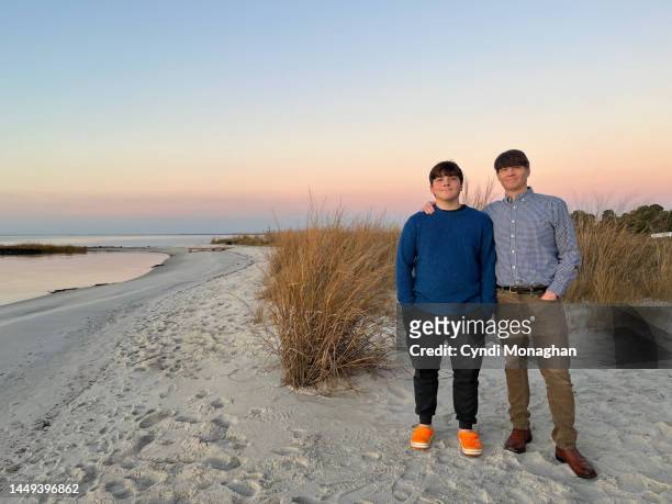 father with his son enjoying thanksgiving sunset on the eastern shore of the chesapeake bay. tangier sound. - happy thanksgiving beach 個照片及圖片檔