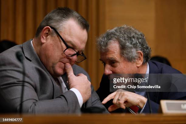 Senate Banking, Housing and Urban Affairs Committee Chairman Sherrod Brown talks with committee member Sen. Jon Tester during a hearing about the...