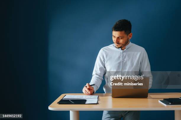 smiling businessman working at home - man standing desk stock pictures, royalty-free photos & images