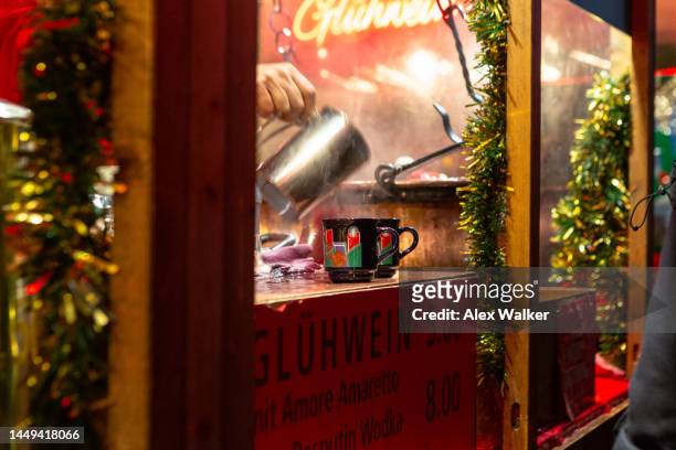 person pouring glühwein (mulled wine) into decorative mugs, basel, switzerland - christkindlmarkt stock-fotos und bilder