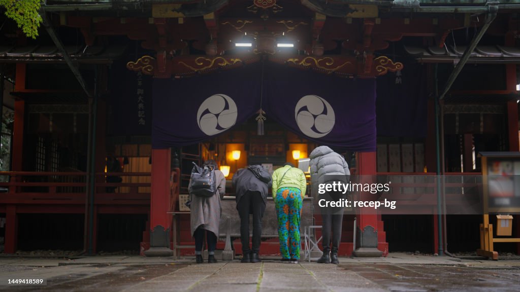 Gruppe multirassischer Freunde, die den Schrein besuchen und beten