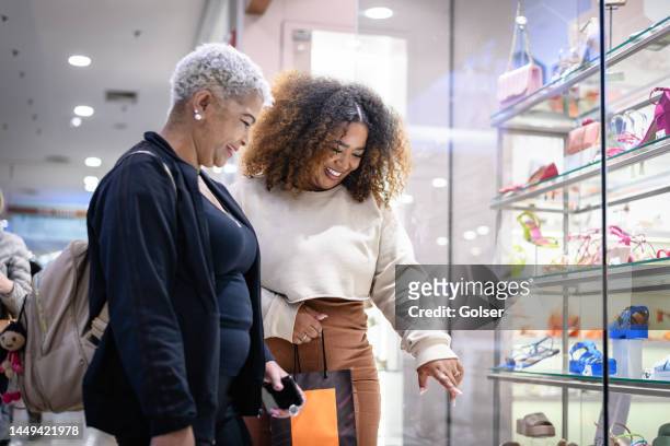 mother and daughter looking for shoes in a store window - systemic lupus erythematosus stock pictures, royalty-free photos & images