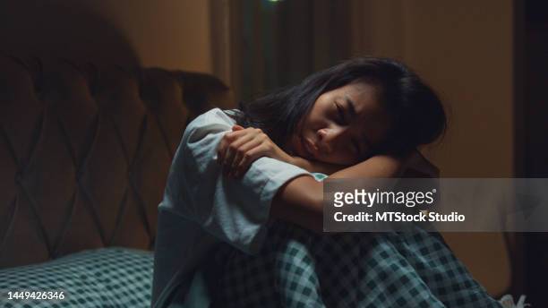 triste ragazza asiatica depressa a letto. persona sola con stress, insonnia e disturbi del sonno. - online bullying foto e immagini stock