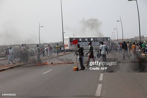 Some of thousands of Malians walk by burning tyres during a protest on May 21, 2012 in Bamaka against a transition deal giving coup leader Amadou...