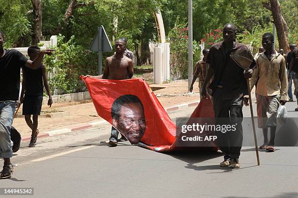 Some of thousands of Malians protest on May 21, 2012 in Bamako, dragging a portrait of current interim leader Dioncounda Traore, against a transition...