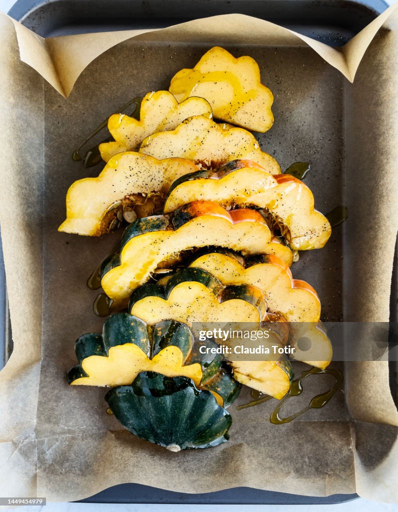 Slices of acorn squash on a tray on parchment paper