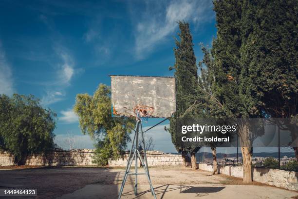 old weathered basketball hoop against blue sky - abandoned playground stock pictures, royalty-free photos & images