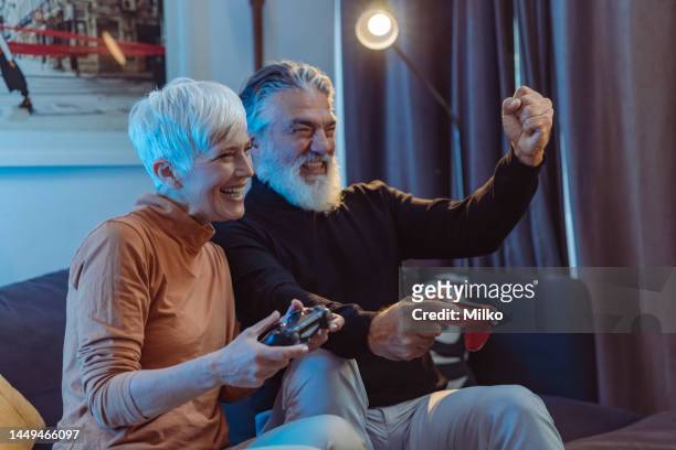 excited senior couple playing video games - the short game stock pictures, royalty-free photos & images