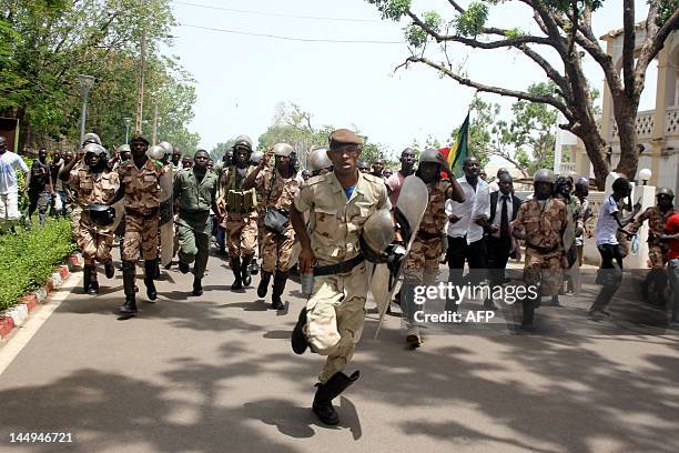 Presidential guards run to prevent some of thousands of Malians from storming on May 21, 2012 the presidential compound in Bamako during a protest...