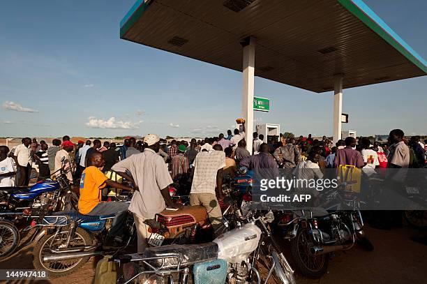Men line-up in a cue as they wait to refuel their motorcycles at a gas station on the outskirts of Juba, South Sudan on May 18, 2012. Since the...