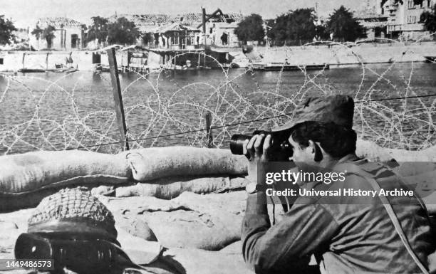 An Israeli soldier looks through his binoculars across the Suez Canal during the 1970 ceasefire agreement between Israel and Egypt. The ceasefire...