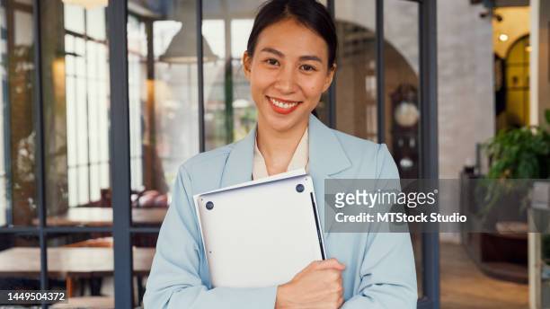 young asian woman looking at camera and smiling in cafe. - bank office clerks stock pictures, royalty-free photos & images