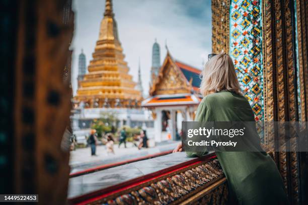 jovem mulher explorando o grande palácio em bangkok - bangkok - fotografias e filmes do acervo