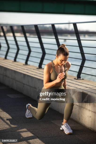 young female athlete doing stretching before run - jogging pants stock pictures, royalty-free photos & images