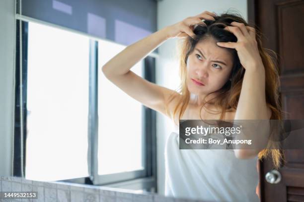 asian woman scratching her scalp caused of itchy scalp. - dermatitis seborreica fotografías e imágenes de stock