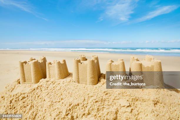 sand castle at beach and sea against sky - château de sable photos et images de collection