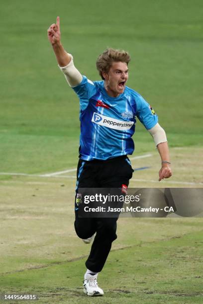 Henry Thornton of the Strikers celebrates after taking the wicket of Jason Sangha of the Thunder during the Men's Big Bash League match between the...