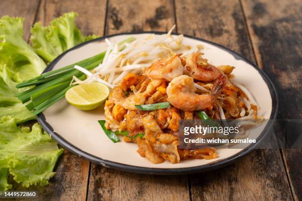 pad thai stir fried asian noodles with shrimp, egg, tofu and bean sprouts - bean sprouts stock pictures, royalty-free photos & images