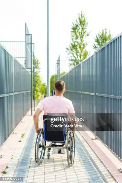 unrecognizable man with tattoos sitting in wheelchair outdoors - basketball all access stock pictures, royalty-free photos & images