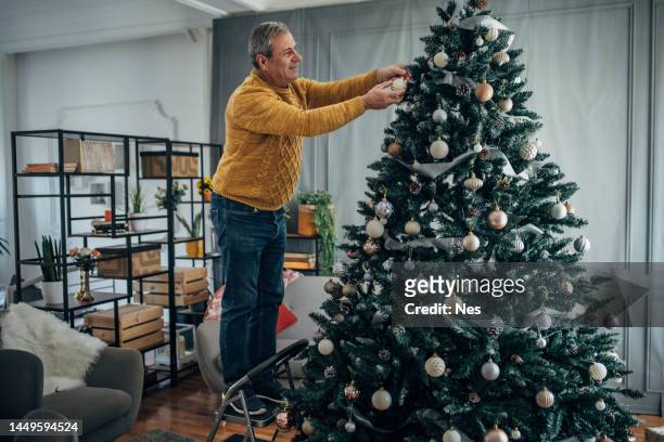decorating the christmas tree, lonely man - kerstboom versieren stockfoto's en -beelden