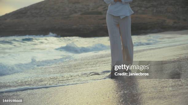 woman standing alone on a beach. looking off into distant sea and feeling sand with bare feet - i miss you stock pictures, royalty-free photos & images