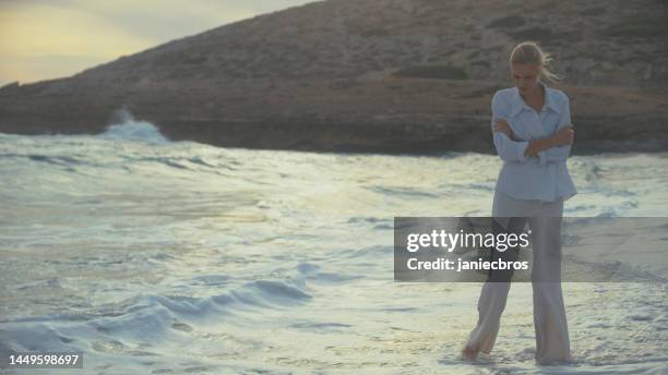 woman standing alone on a beach. looking off into distant sea horizon - i miss you stock pictures, royalty-free photos & images