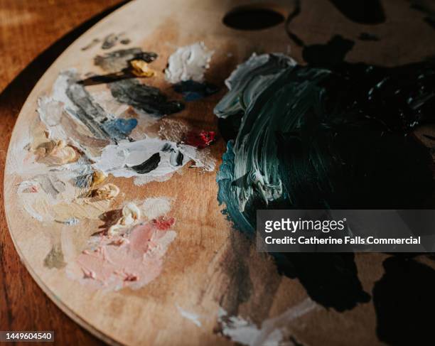 dried oil paint on a wooden artists palette - kunstgemälde stock-fotos und bilder
