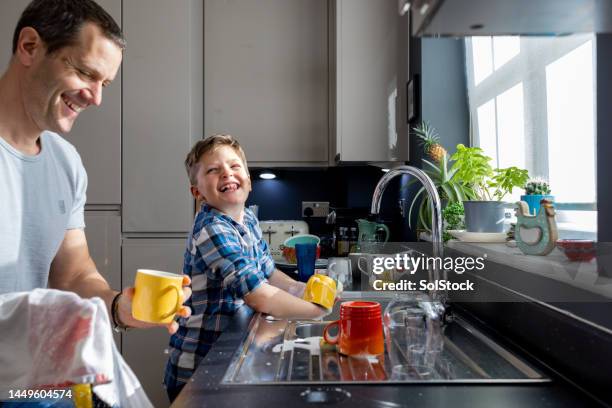 papa beim abwasch helfen - wash the dishes stock-fotos und bilder