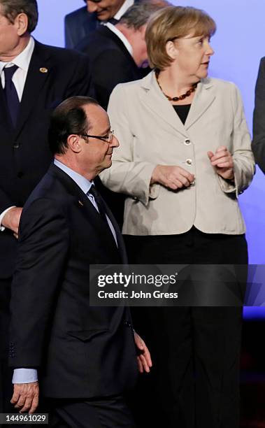 French President Francois Hollande walks past German Chancellor Angela Merkel as they arrive for a group photo during the NATO summit on May 21, 2012...