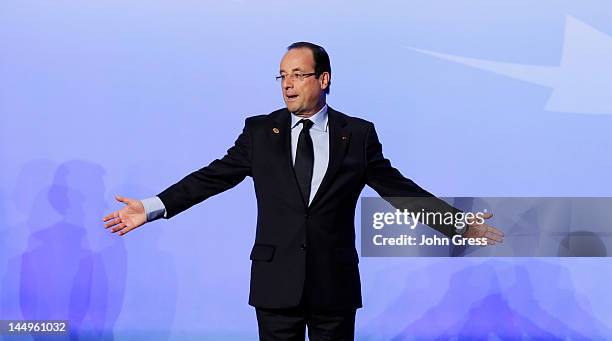 French President Francois Hollande gestures to reporters and photographers after posing for a group photo during the NATO summit on May 21, 2012 at...