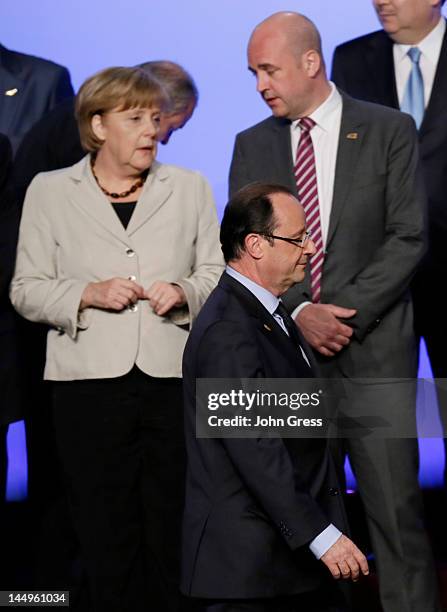 French President Francois Hollande walks past German Chancellor Angela Merkel and Swedish Prime Minister Fredrik Reinfeldt as they arrive for a group...