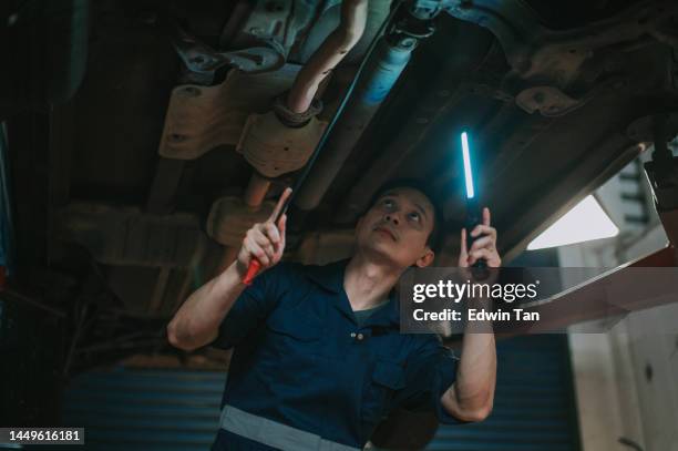 asian chinese male mechanic checking car undercarriage in auto repair shop - car suspension stock pictures, royalty-free photos & images