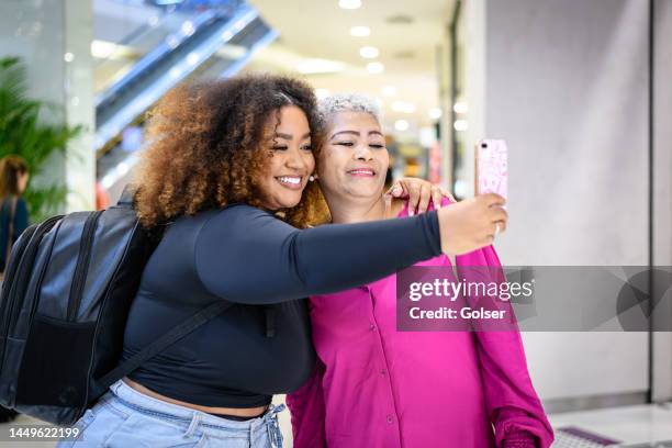 mother and daughter taking a selfie at the mall - systemic lupus erythematosus stock pictures, royalty-free photos & images